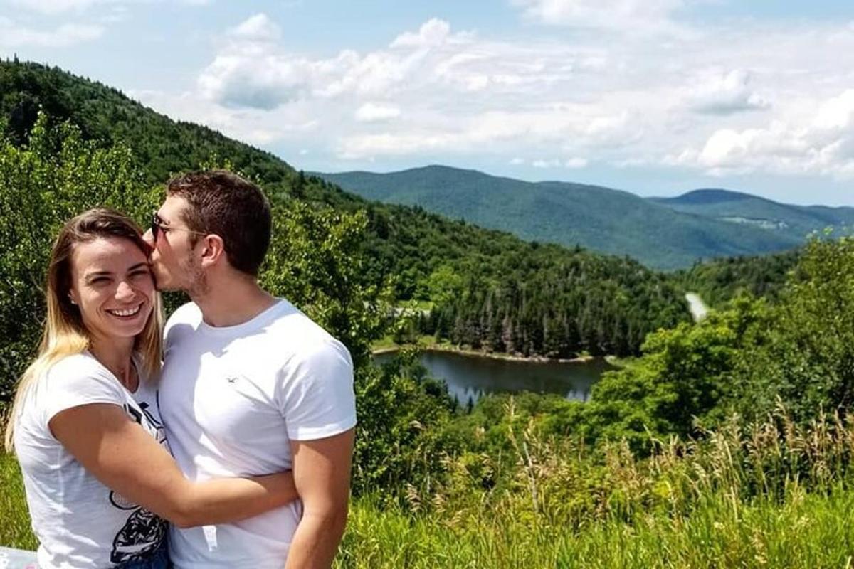 a man and a woman standing on top of a mountain
