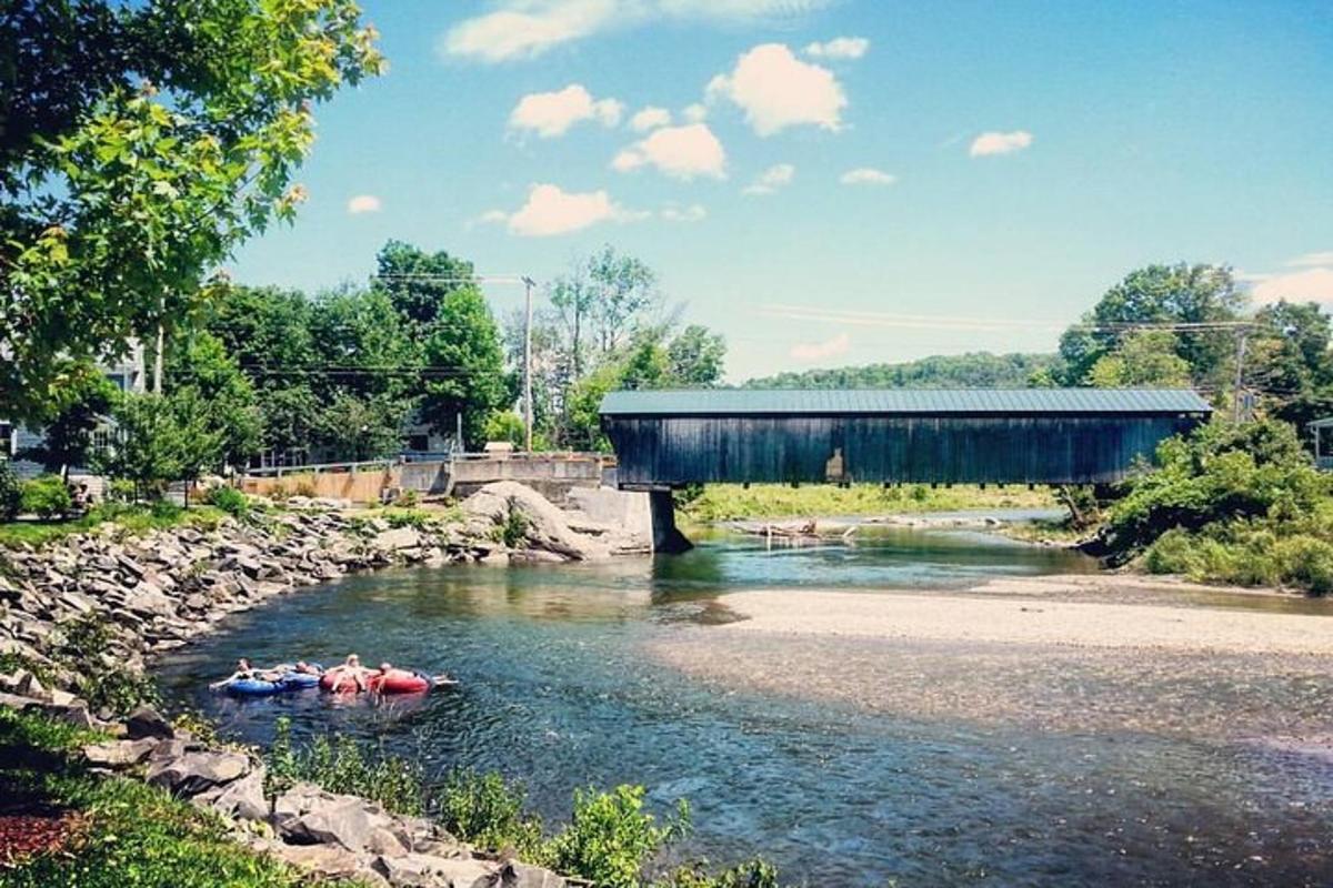 a group of people in kayaks under a covered bridge