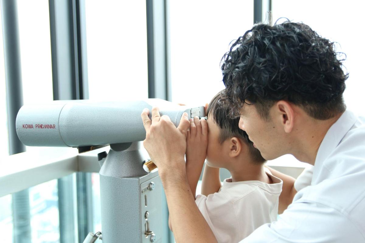 a man looking through a microscope with a boy