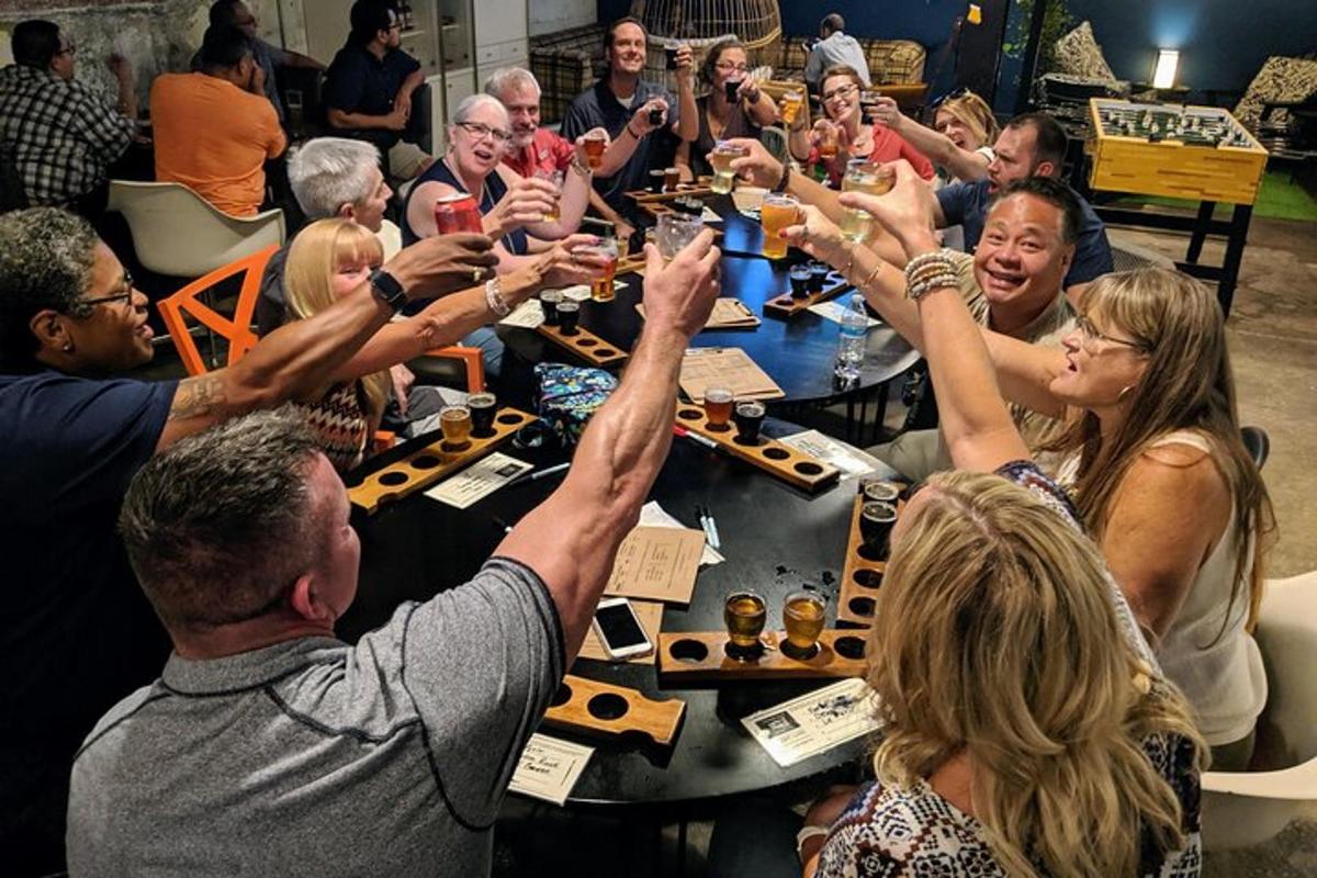 a group of people sitting around a table raising their hands