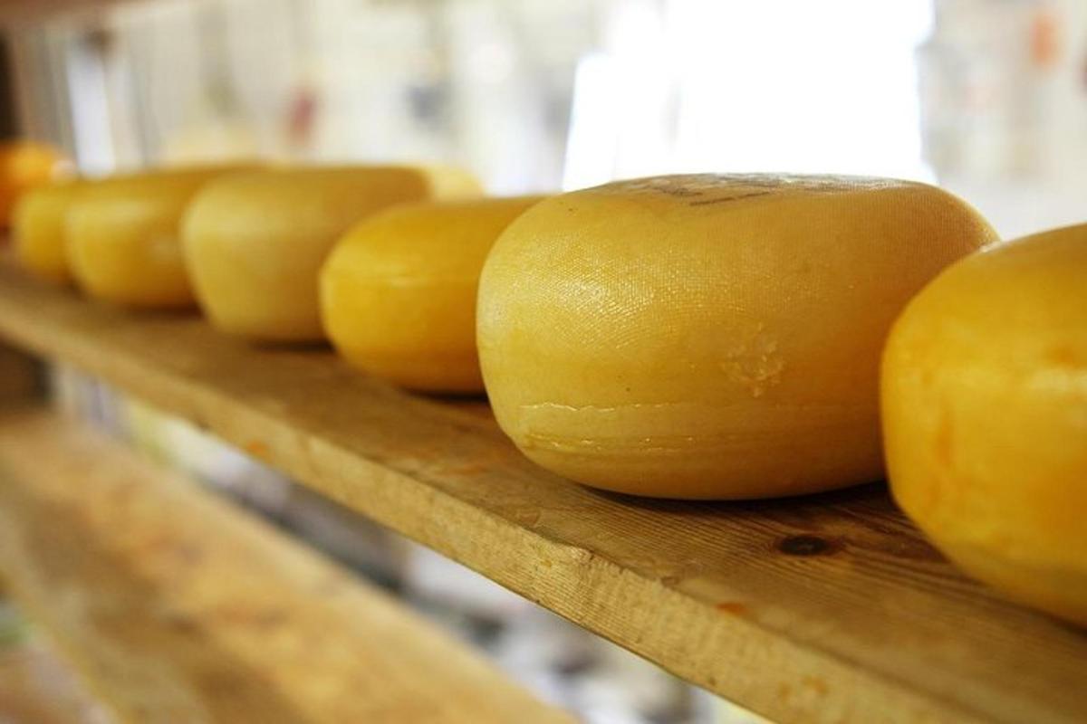 a row of yellow apples sitting on a wooden shelf