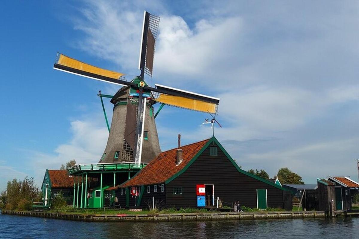 a building with a windmill next to the water