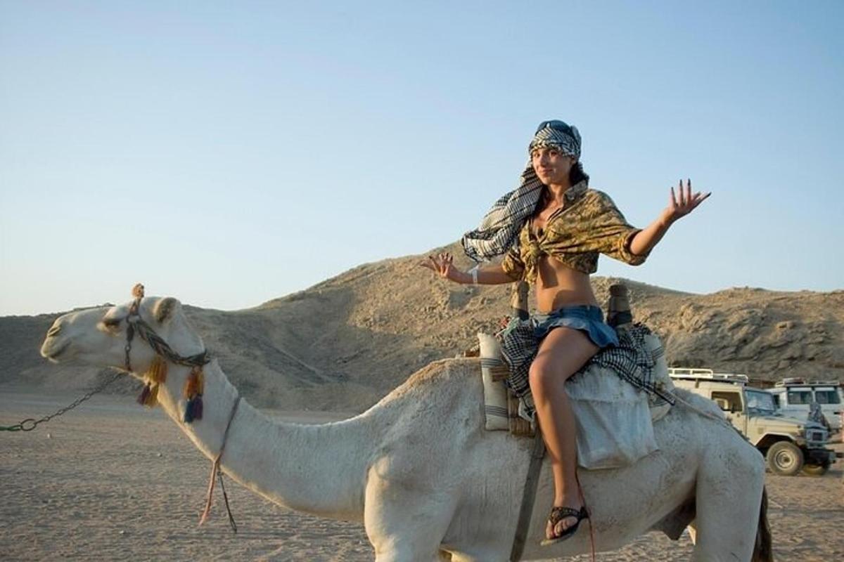 una donna a cavallo di un cammello nel deserto