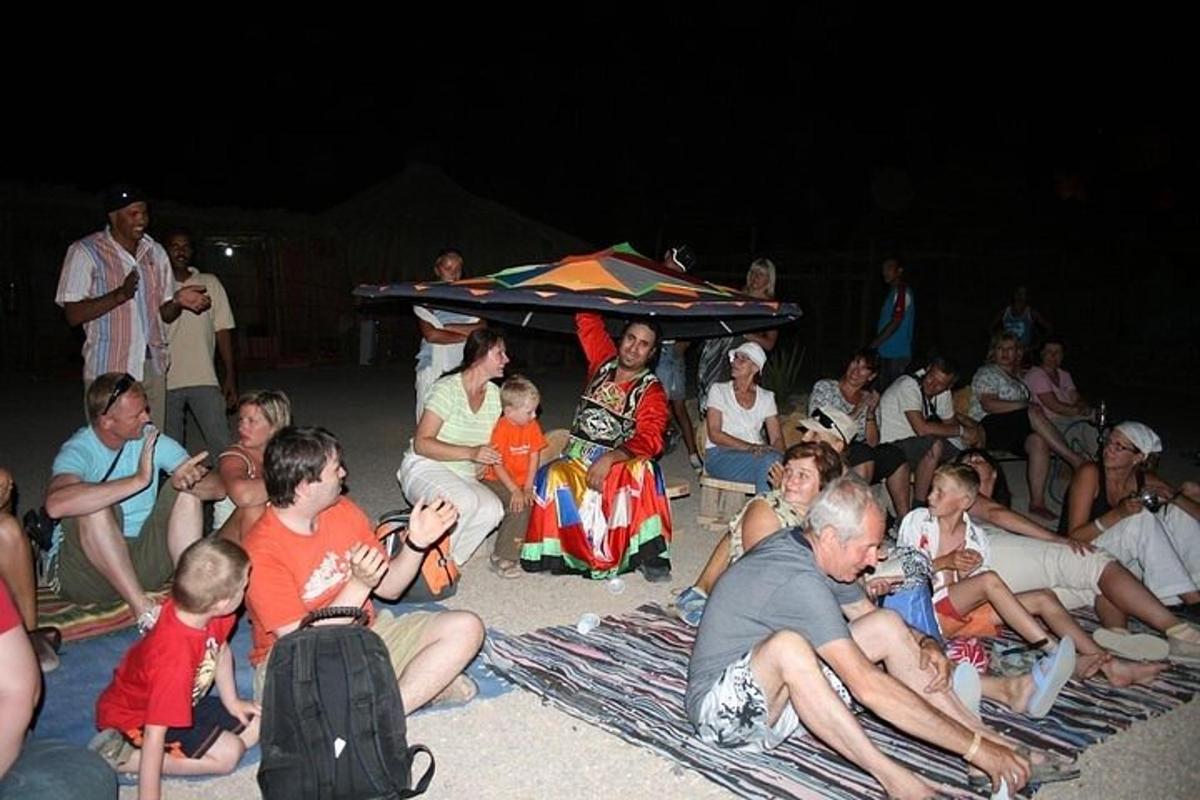 un gruppo di persone sedute sulla spiaggia di notte