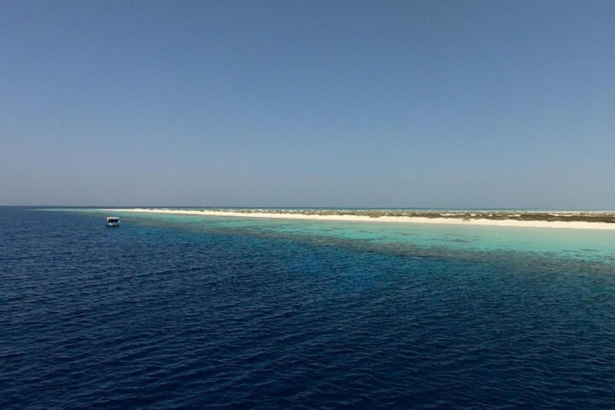 an island in the ocean with a boat in the water