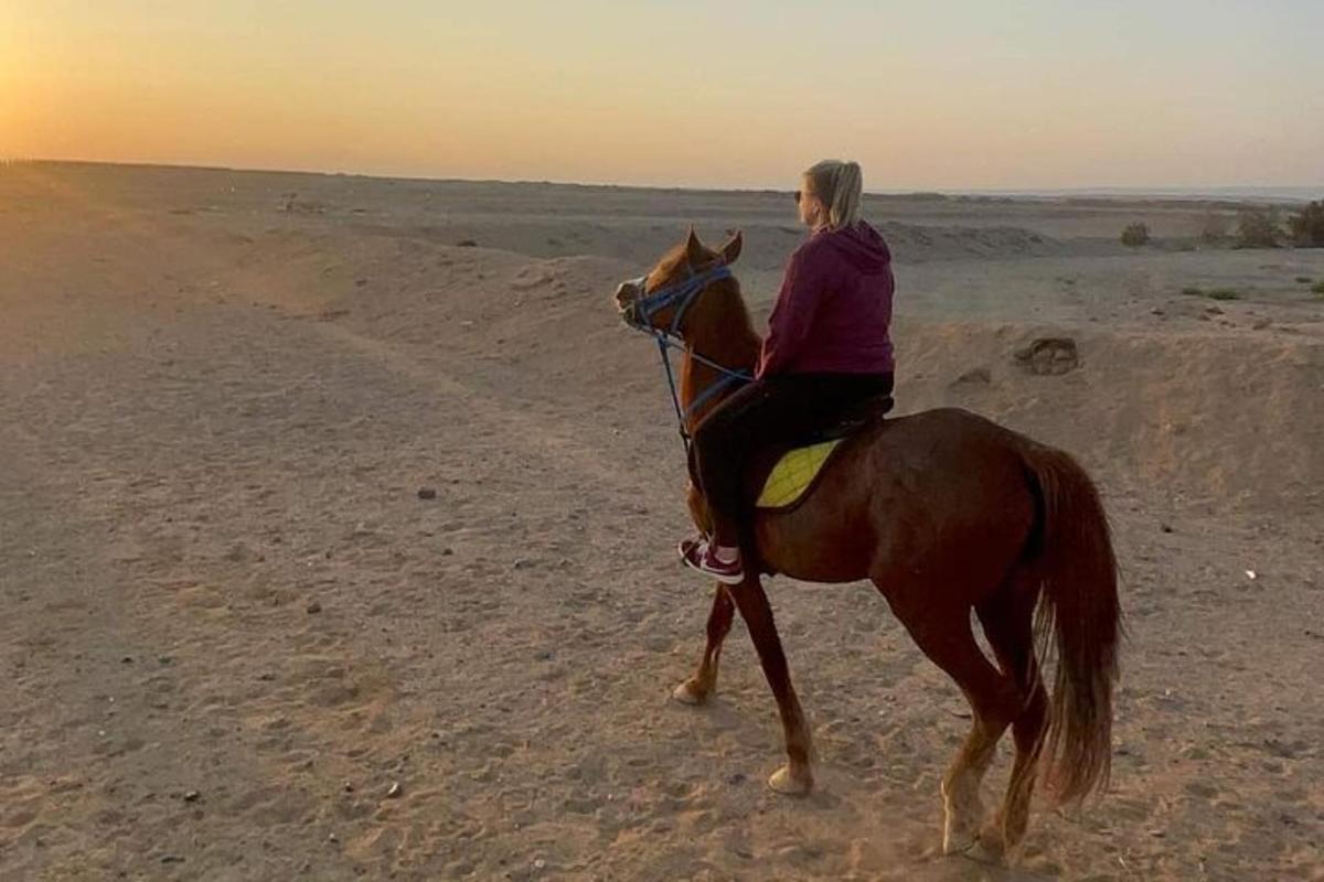 una dona muntant a cavall al desert