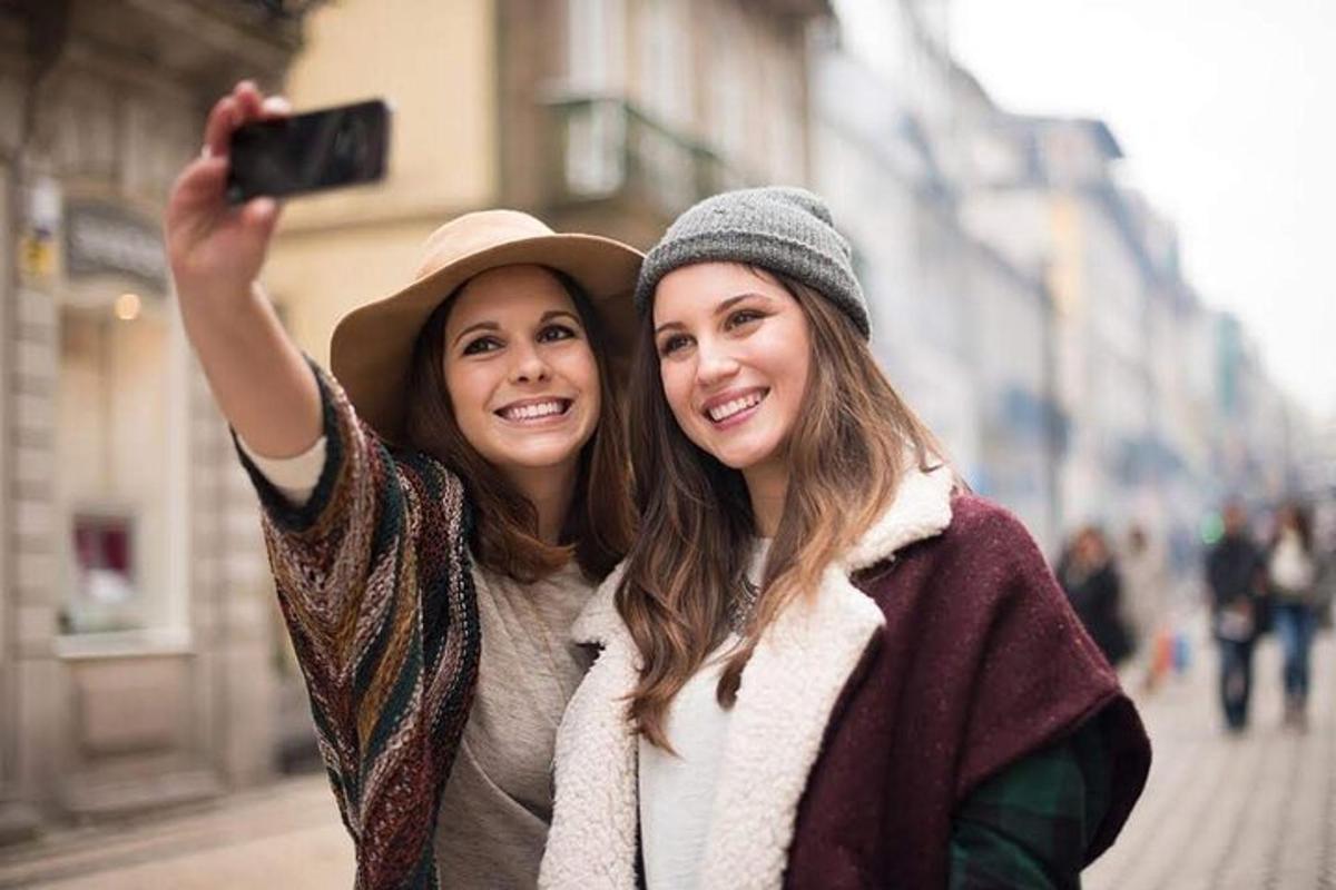 two women standing next to each other taking a picture