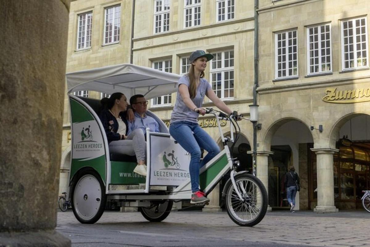 a woman riding a bike pulling a cart with people