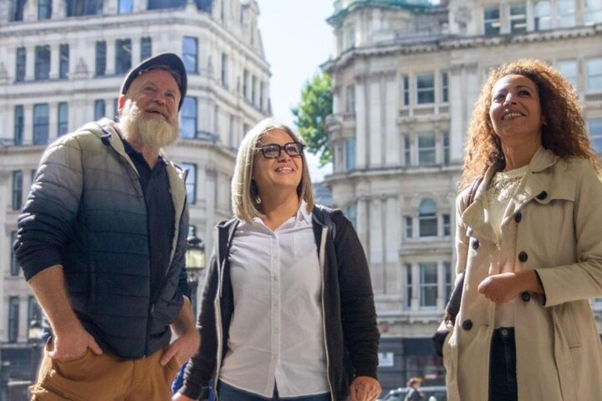 a group of three people standing in front of a building