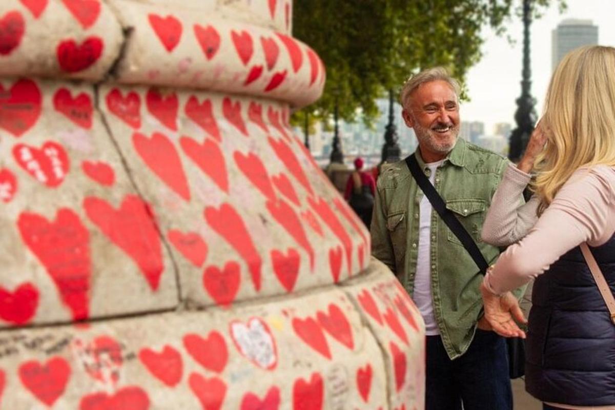 en mand og en kvinde, der står ved siden af en hjertestatue