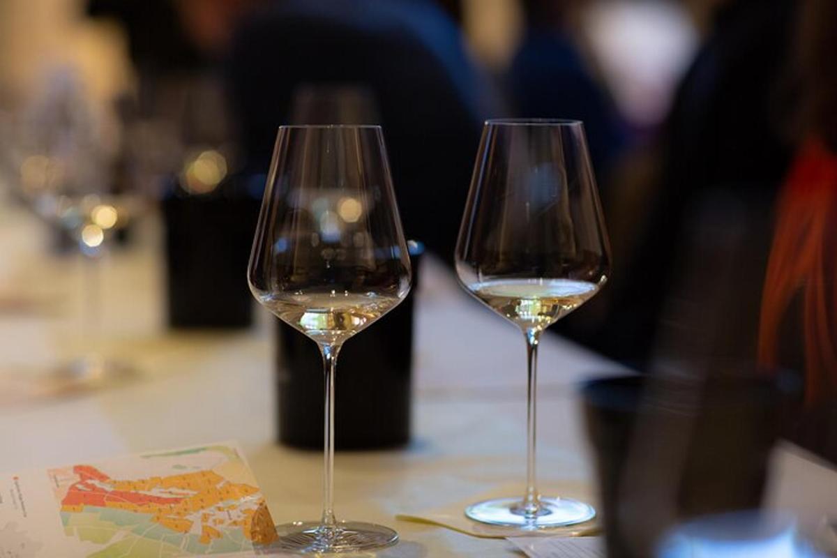 two glasses of white wine sitting on a table