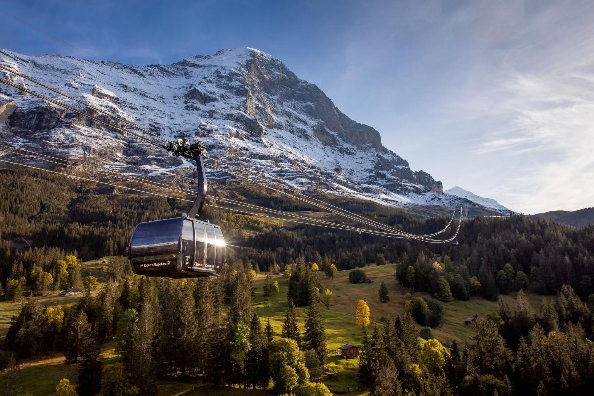 a ski lift in front of a snow covered mountain