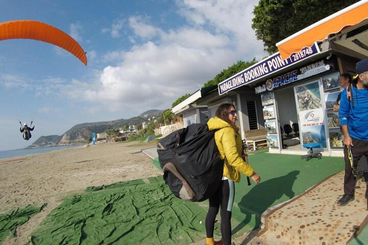 a person standing on a beach with a parachute