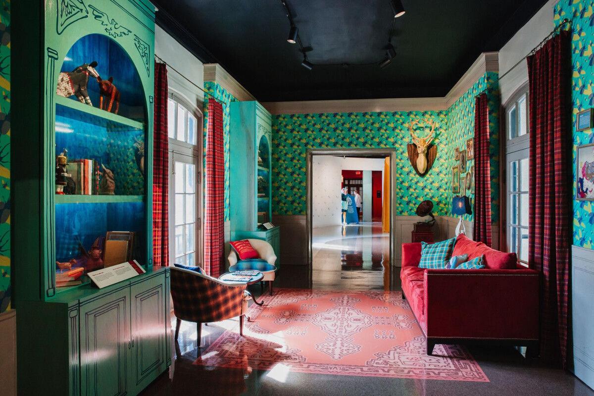 a living room with colorful walls and a red couch
