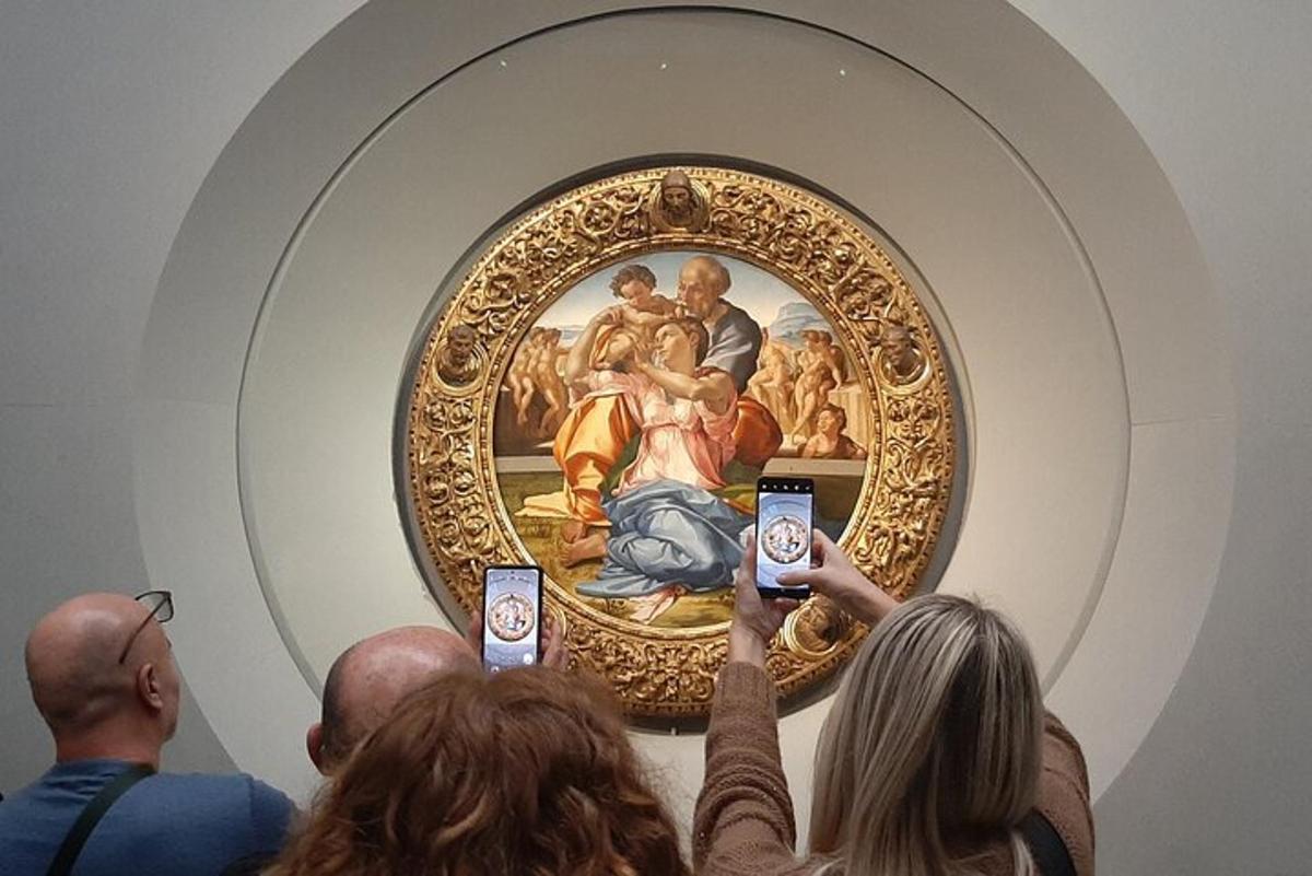 persone che scattano foto di un dipinto in un museo