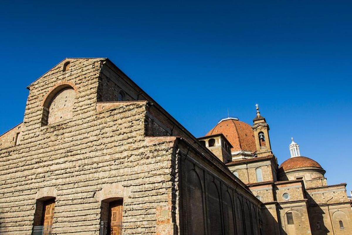 un vecchio edificio in mattoni con una chiesa sullo sfondo
