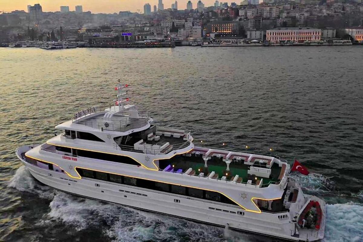 a yacht in the water with a city in the background