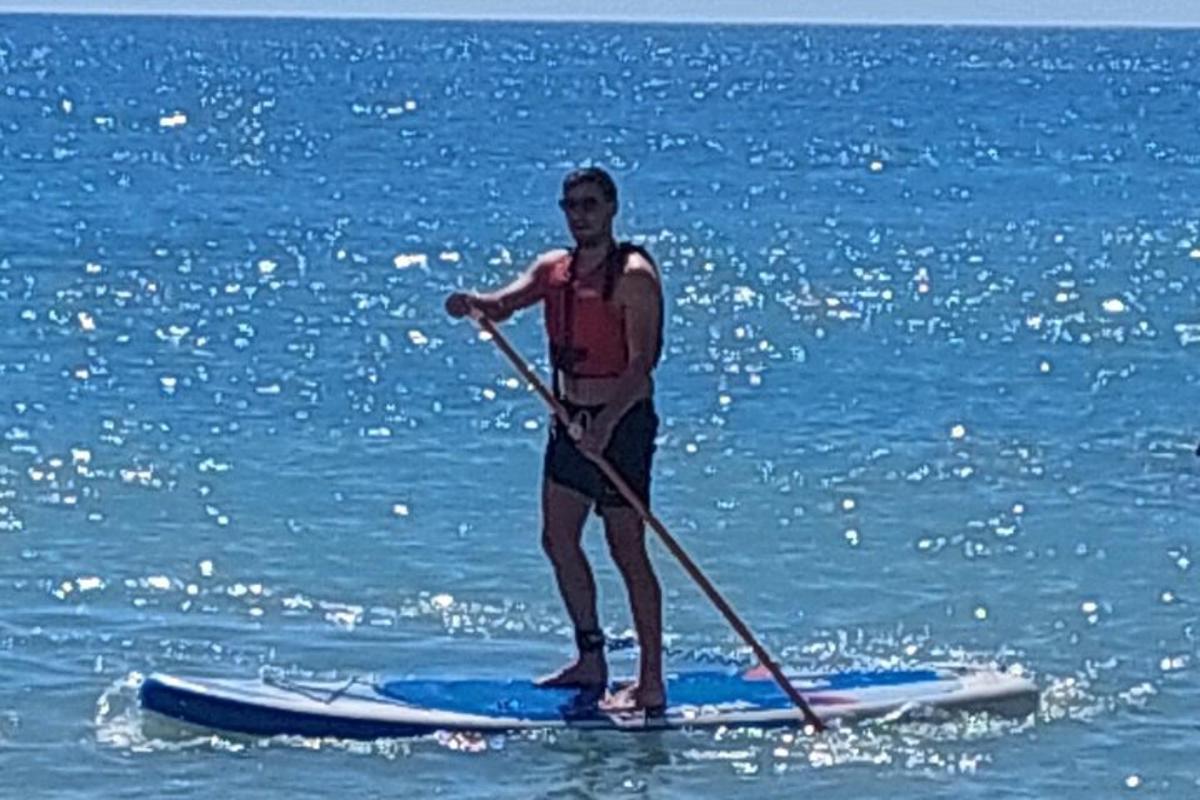 žena stojící na paddleboardu v oceánu