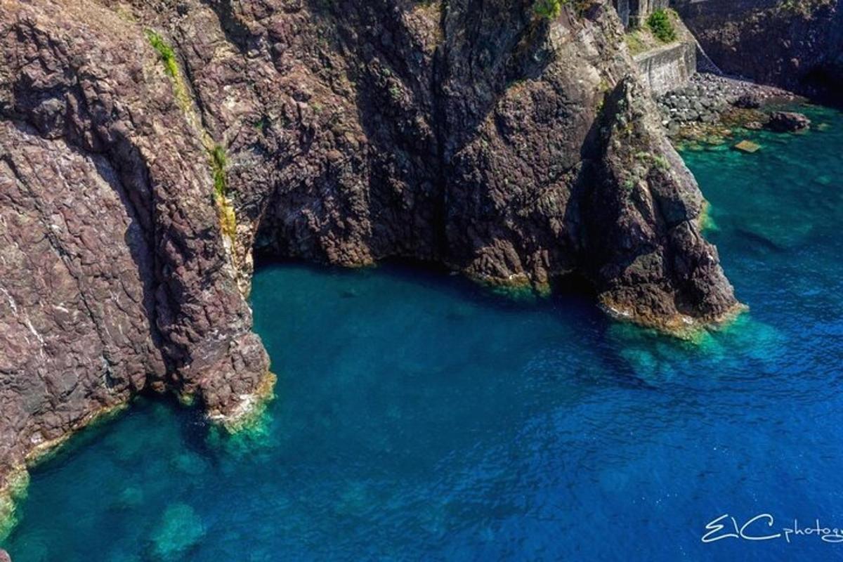 an aerial view of a mountain with blue water