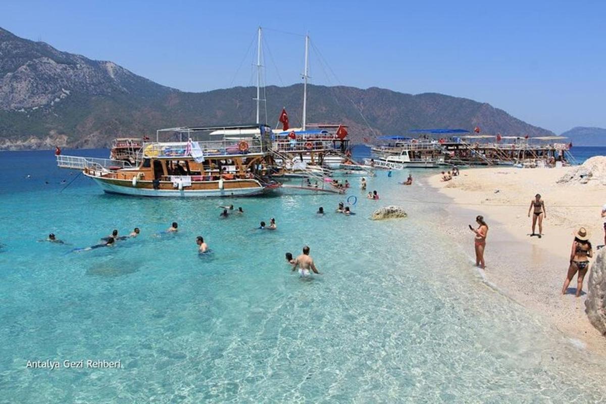 un gruppo di persone in acqua su una spiaggia con barche