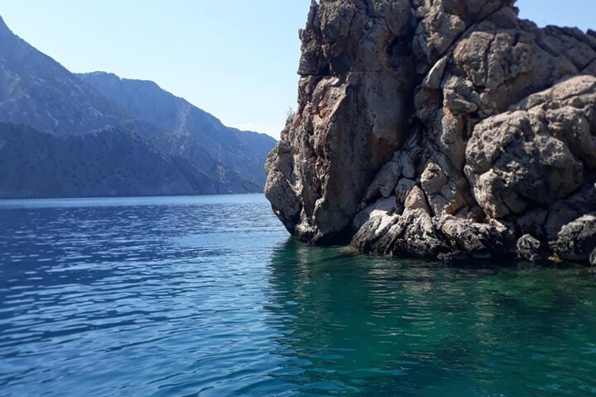 un grande specchio d'acqua accanto a una scogliera rocciosa