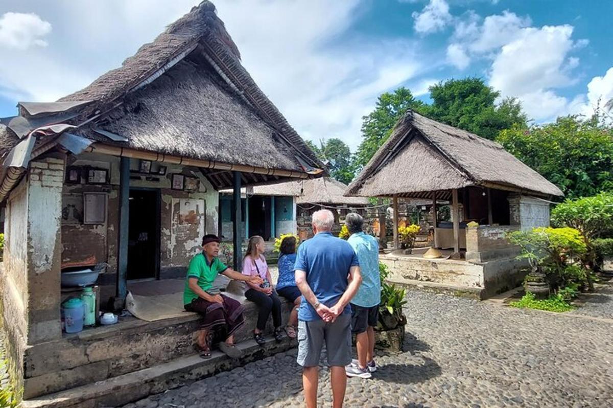 a group of people standing outside of a small house