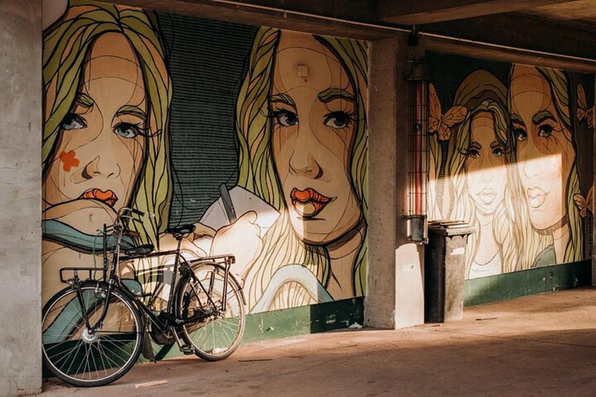 uma bicicleta estacionada em frente a um muro com um mural