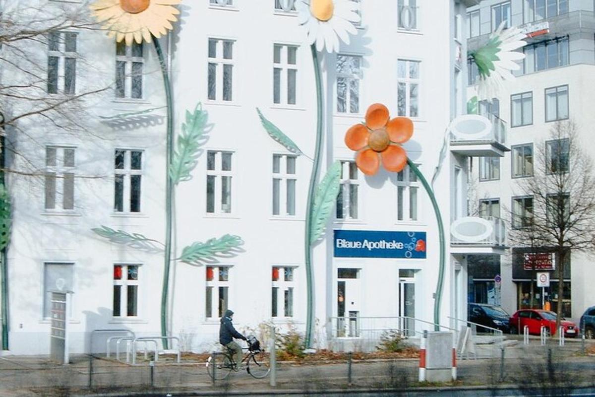 en person som sykler foran en bygning