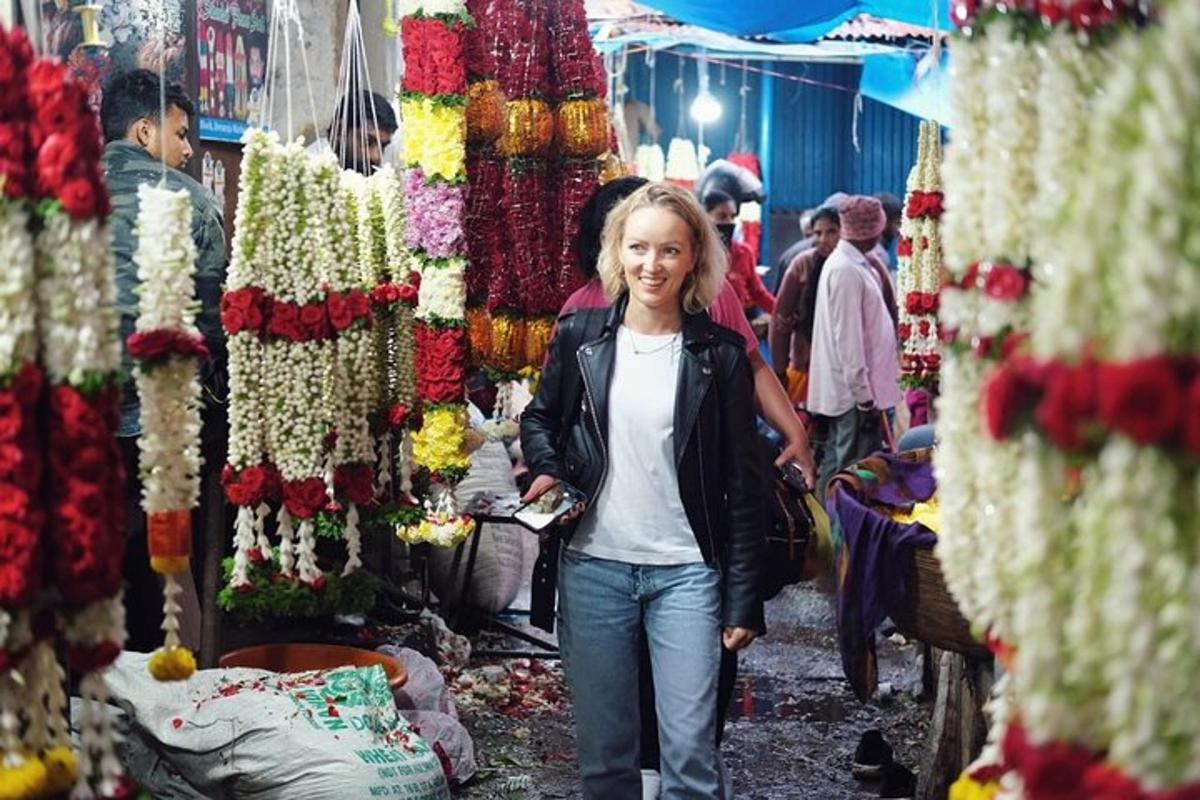a woman walking through a market with flowers