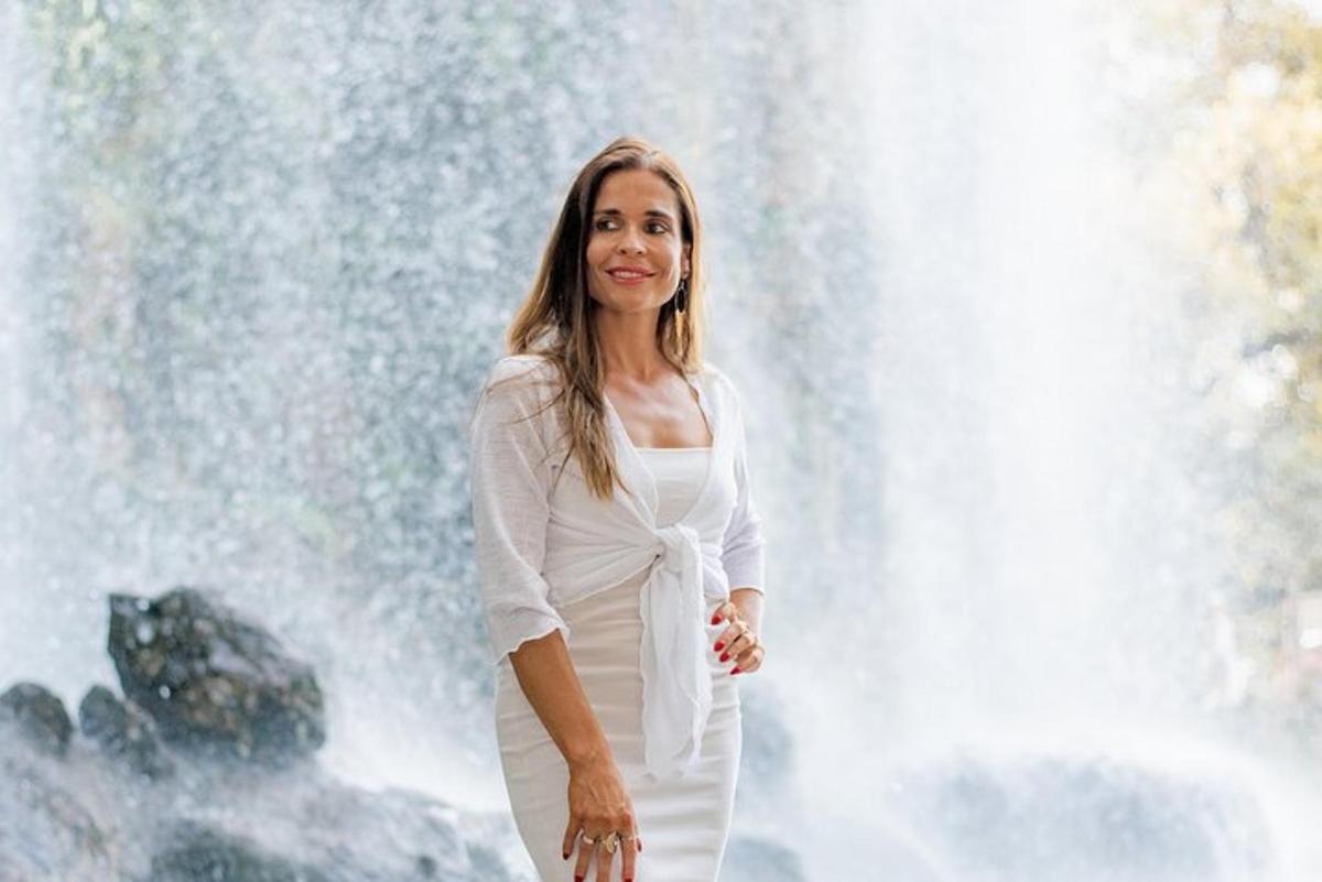 a woman standing in front of a waterfall