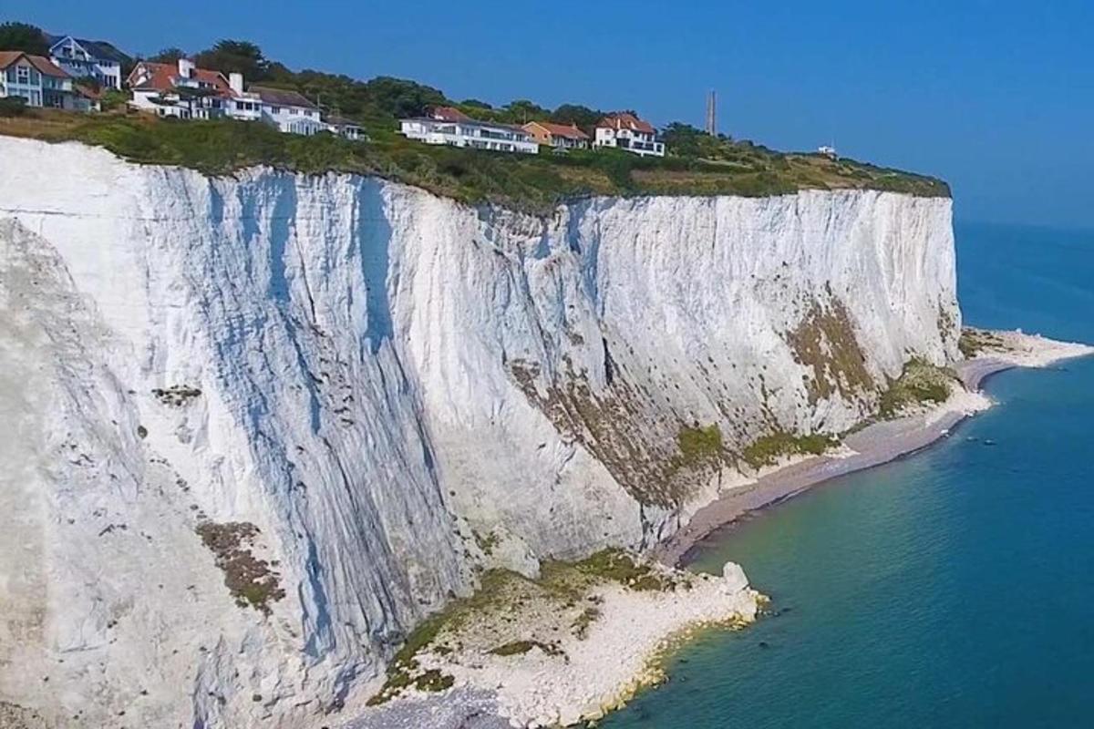a white cliff with houses on it next to the ocean