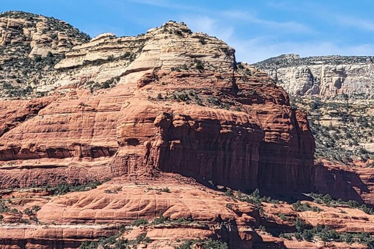a large red rock mountain with trees on it
