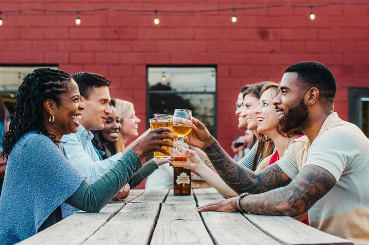 a group of people drinking beer at a wooden table