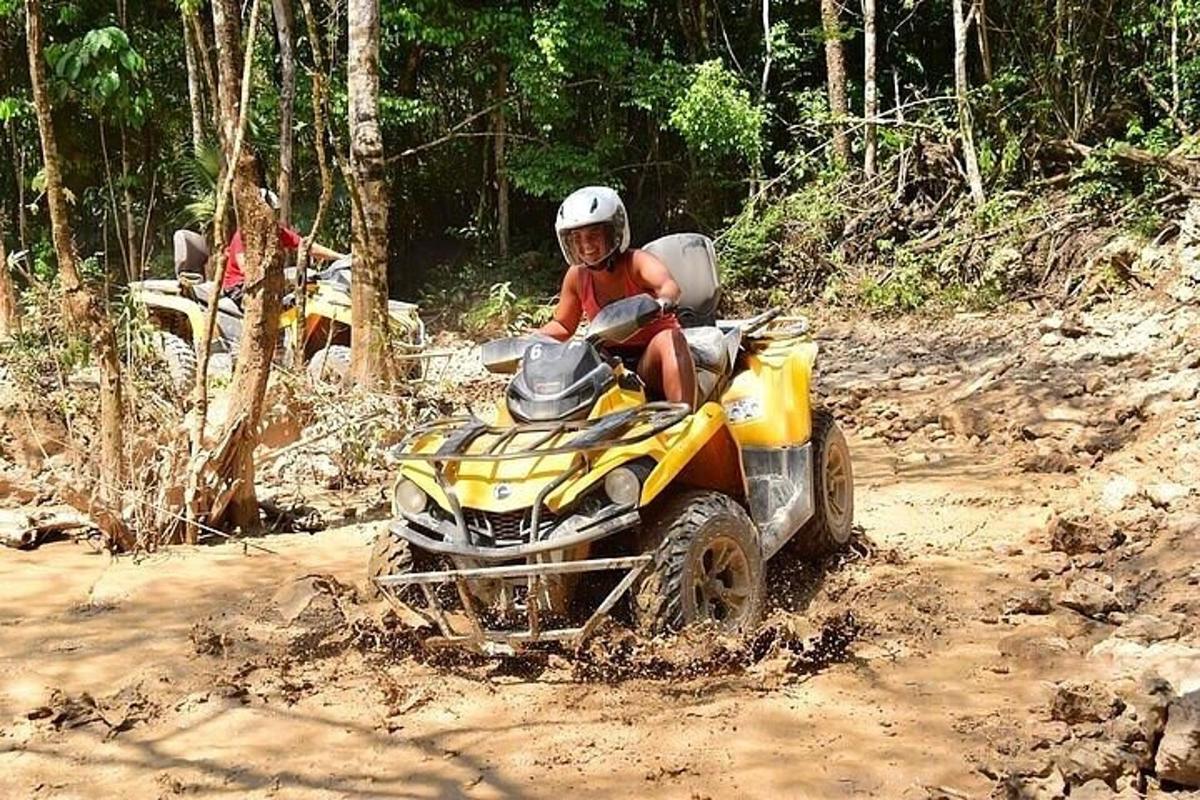 une personne conduisant un véhicule à quatre roues sur un chemin de terre