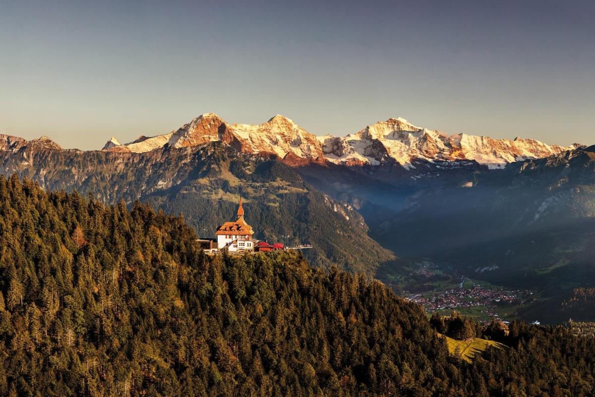 a building on top of a hill with mountains