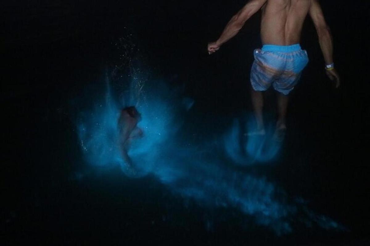 dos personas en el agua en la oscuridad