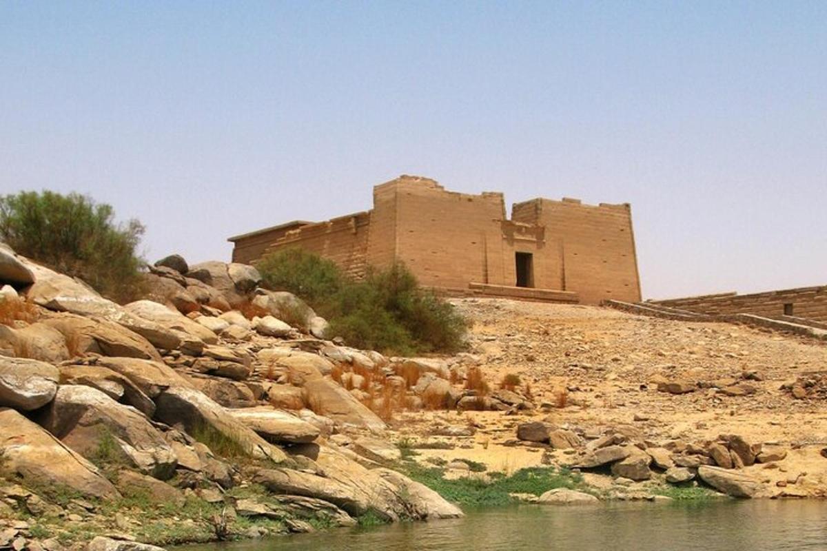 a building on a rocky hill with a body of water