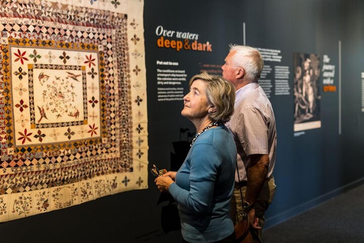 un uomo e una donna guardano un arazzo in un museo