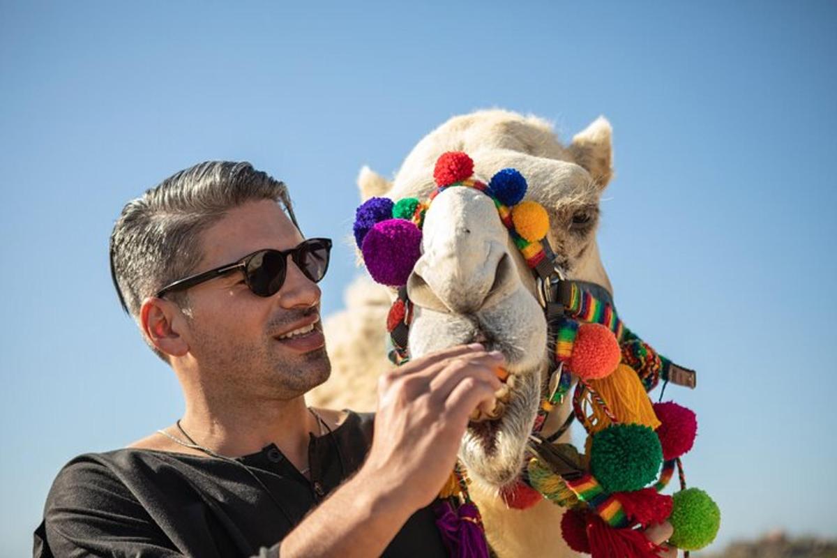 un homme portant des lunettes de soleil tenant un chameau en peluche