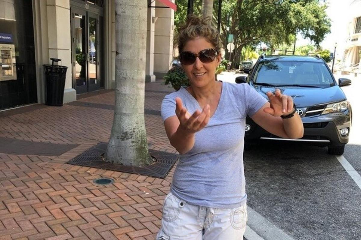 a woman is standing on the street with her hands