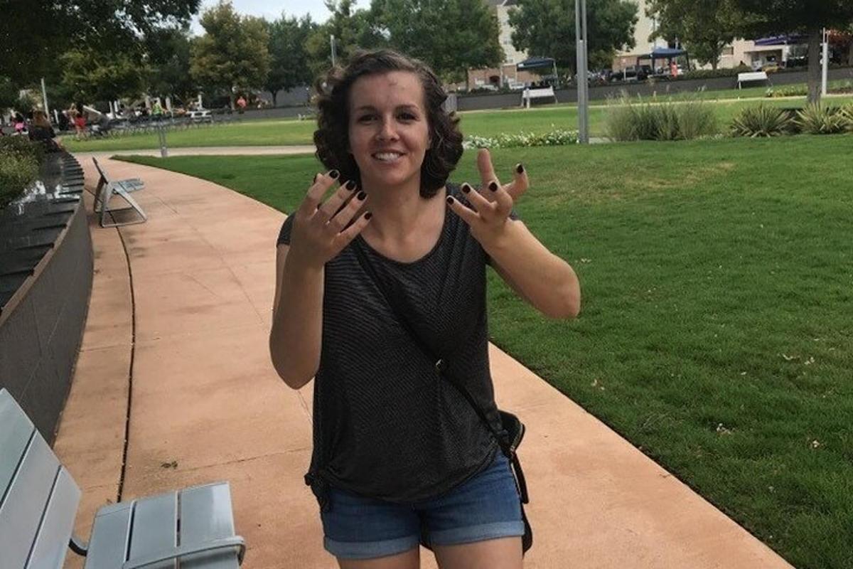 a woman making the peace sign with her hands