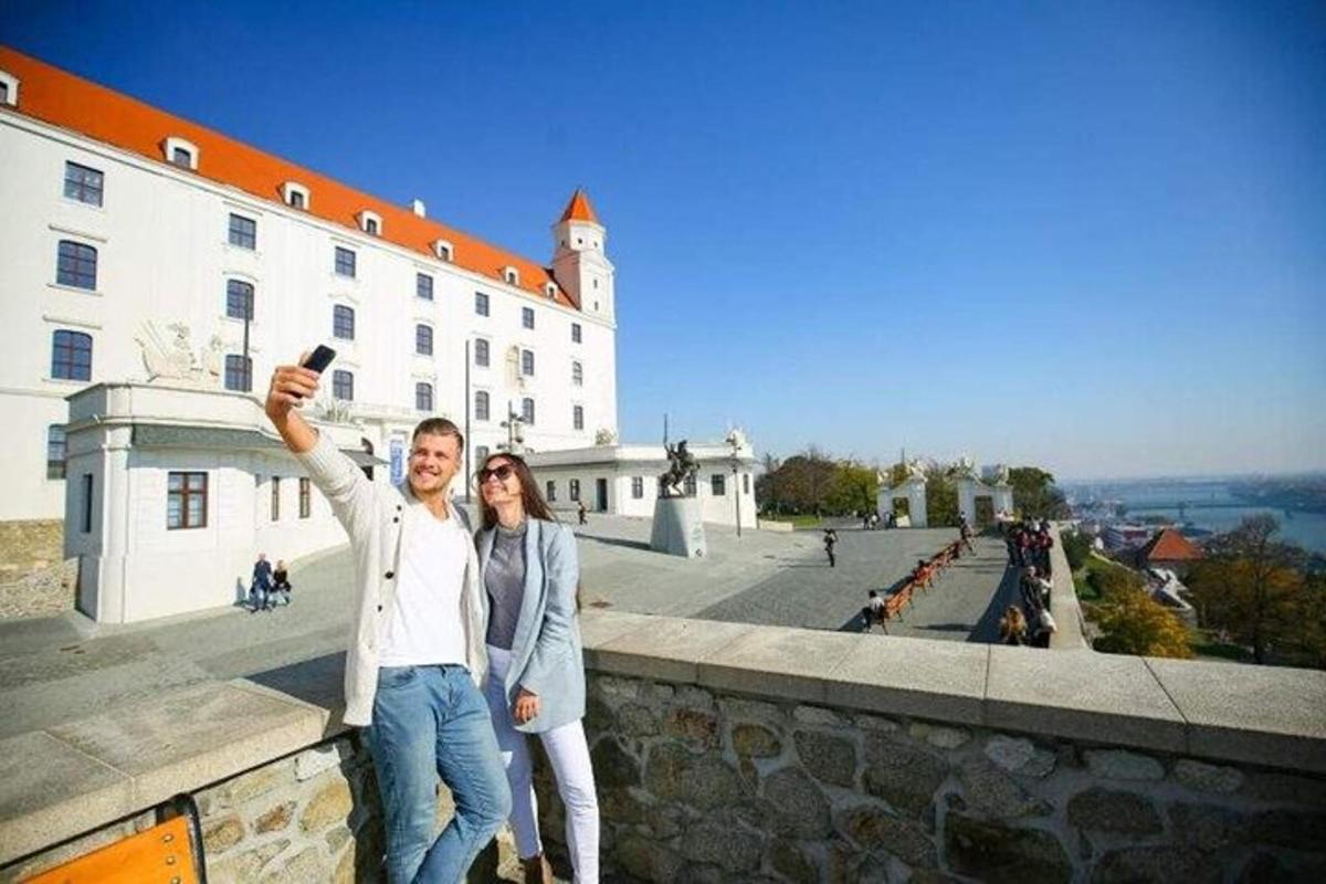 muž a žena fotografují budovu