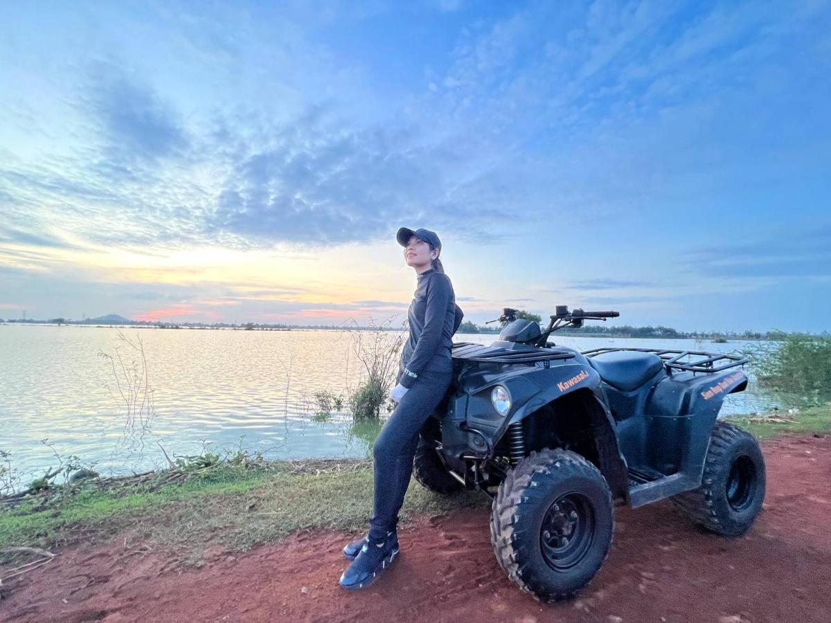 a woman is standing next to a quad bike