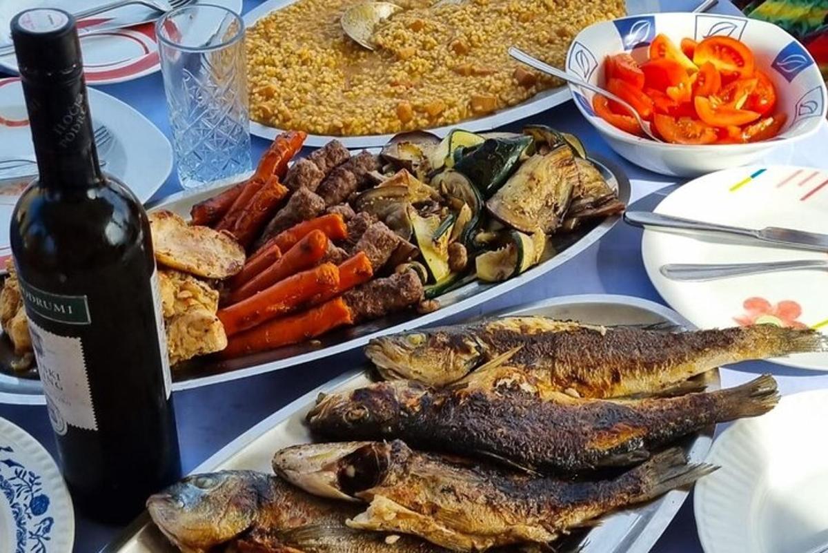 uma mesa com vários pratos de comida e uma garrafa de vinho
