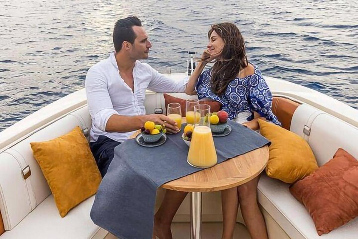ένας άντρας και μια γυναίκα κάθονται σε ένα τραπέζι σε μια βάρκα