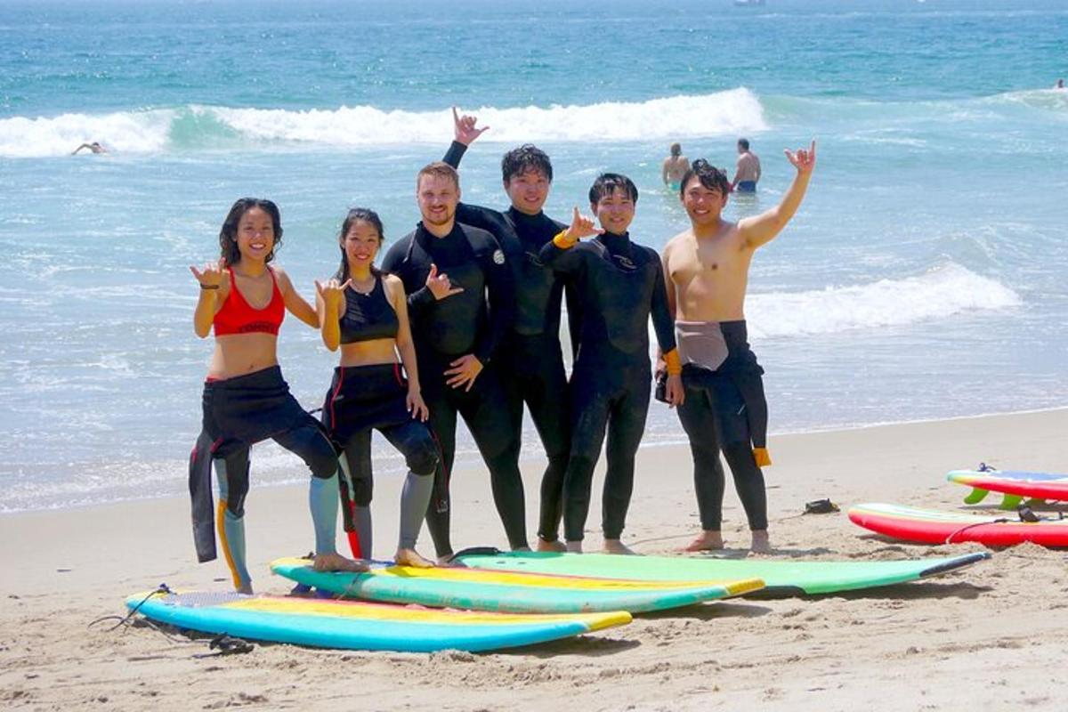 un gruppo di persone in piedi sulla spiaggia con tavole da surf