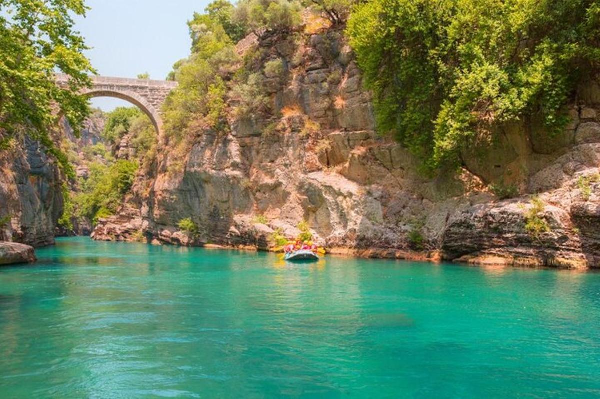 μια βάρκα σε ένα ποτάμι με μια γέφυρα στο φόντο