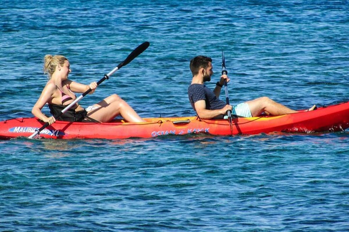 seorang lelaki dan wanita duduk di dalam kayak merah di dalam air