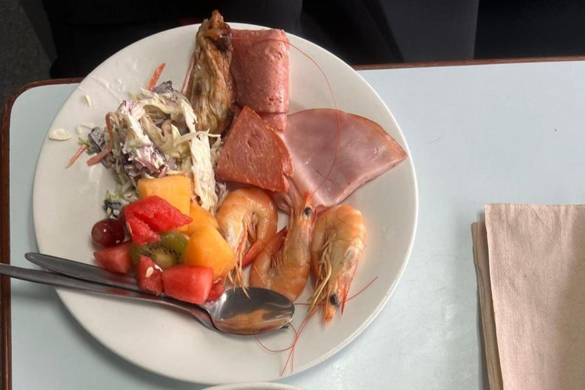 un piatto di cibo con gamberi e frutta su un tavolo