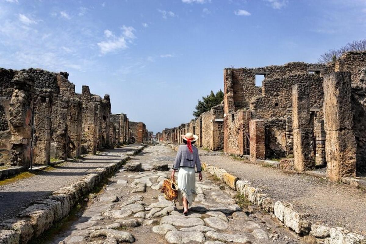una donna che cammina lungo una strada tra le rovine